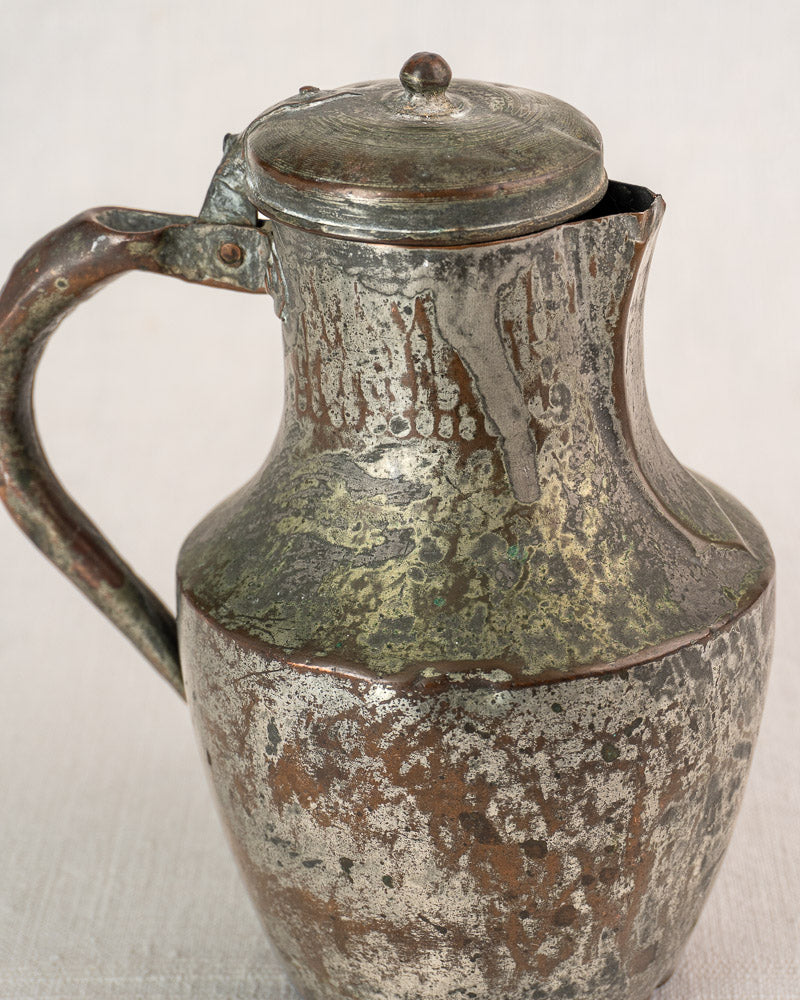 Antique French copper Coquemar pitcher by Allez Frères Paris with hinged lid and curved handle on fabric background.