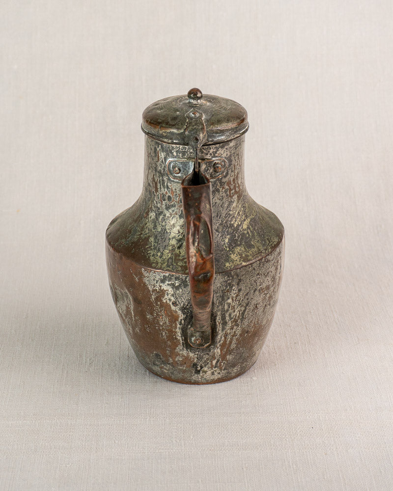 Antique French copper pitcher by Allez Frères Paris with rounded body and hinged lid on textured surface.