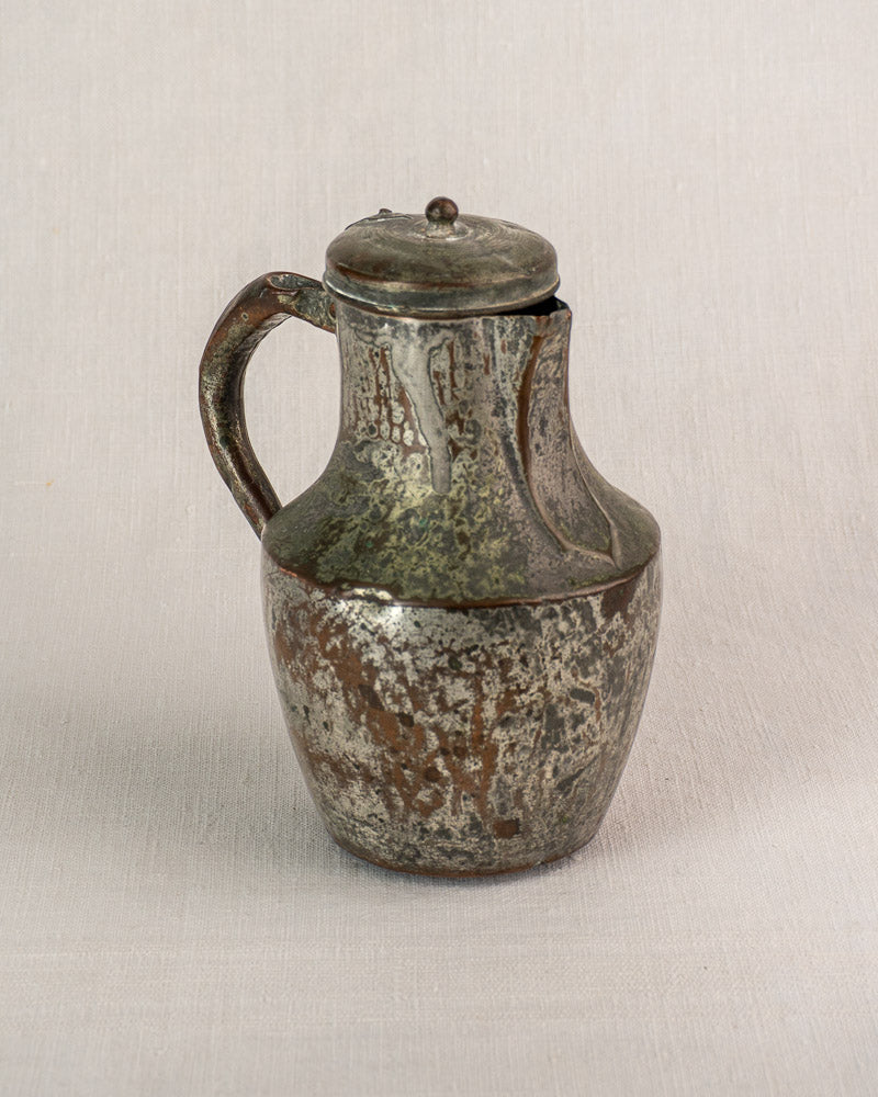Antique French copper pitcher by Allez Frères Paris with rounded body and hinged lid on textured background.