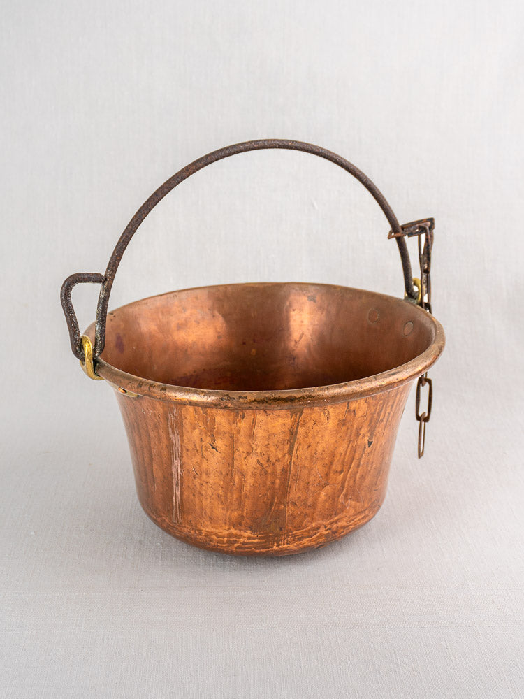 Antique French copper hearth pot petit chaudron with arched iron bail handle, gray background.