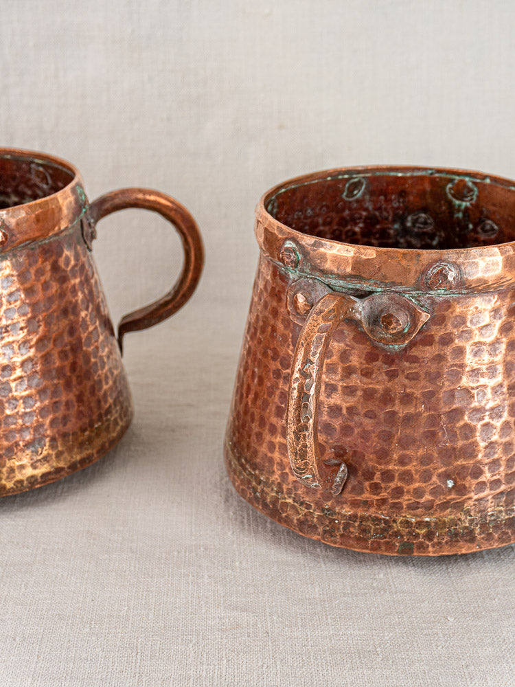 Pair of antique French hand-hammered copper pots, circa 1880-1920, with patina and aged finish.