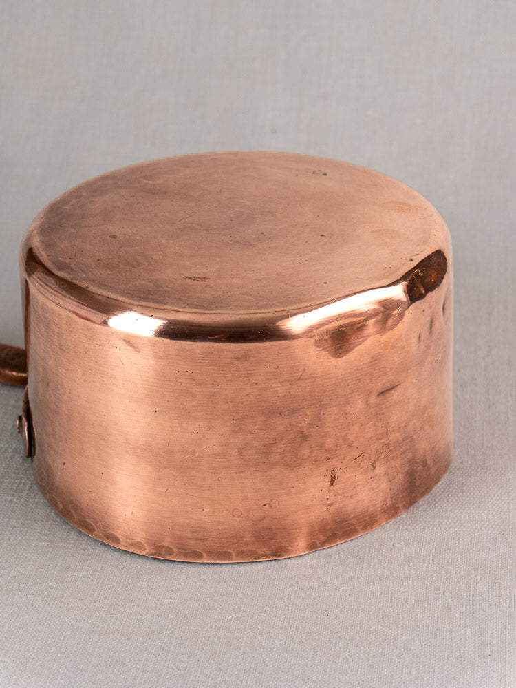 18th-century antique French copper preserving pot with round lid, polished finish, and hand-forged riveted handle on gray background.