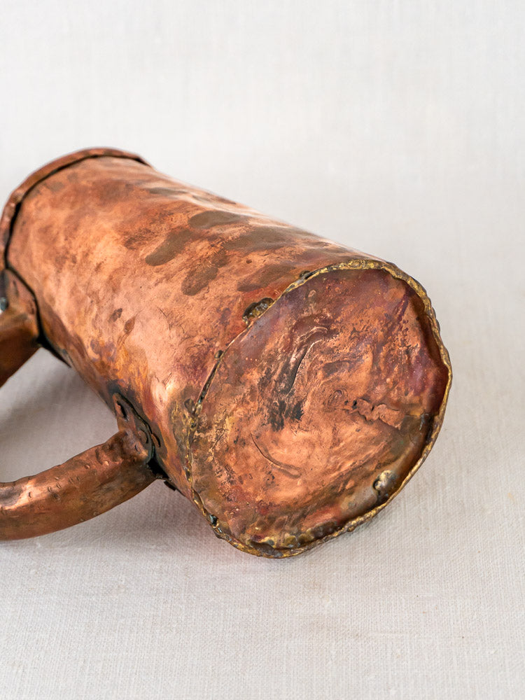 French antique hand-forged copper chope with hammered finish, weathered texture, and visible dents on neutral background.