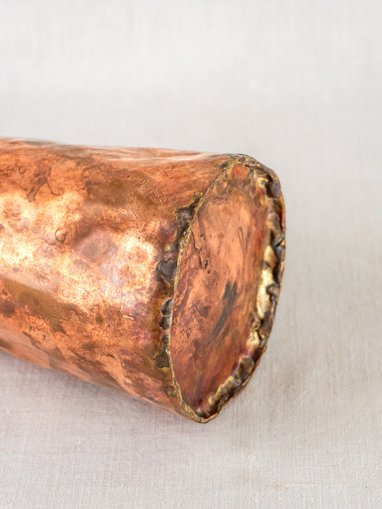 Hand-forged French copper tavern tankard with hammered texture, shown atop a neutral fabric surface.
