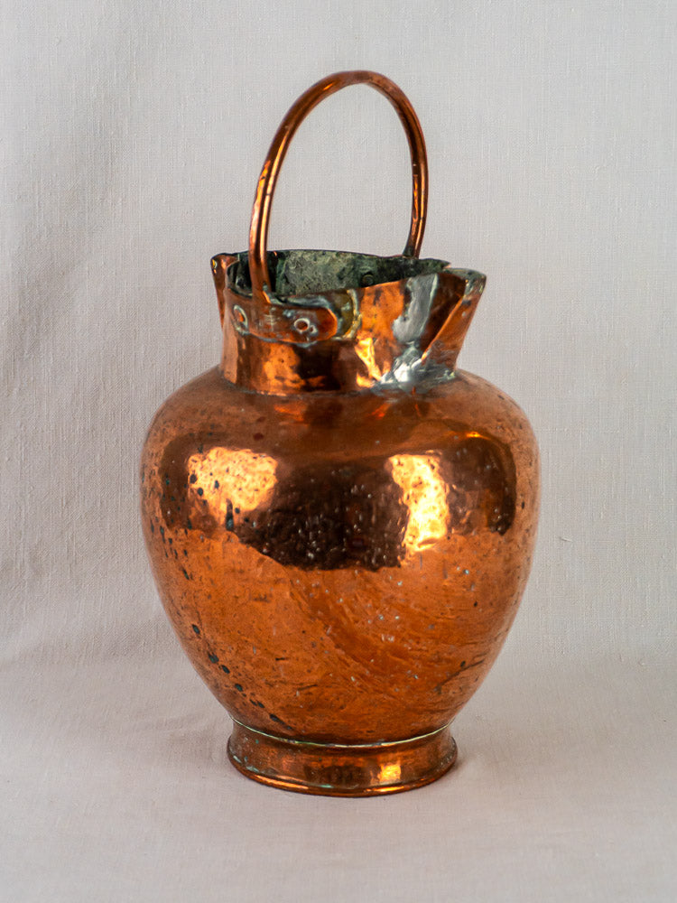 Antique French copper water jug with hammered finish, double spout, and green-patina rim.