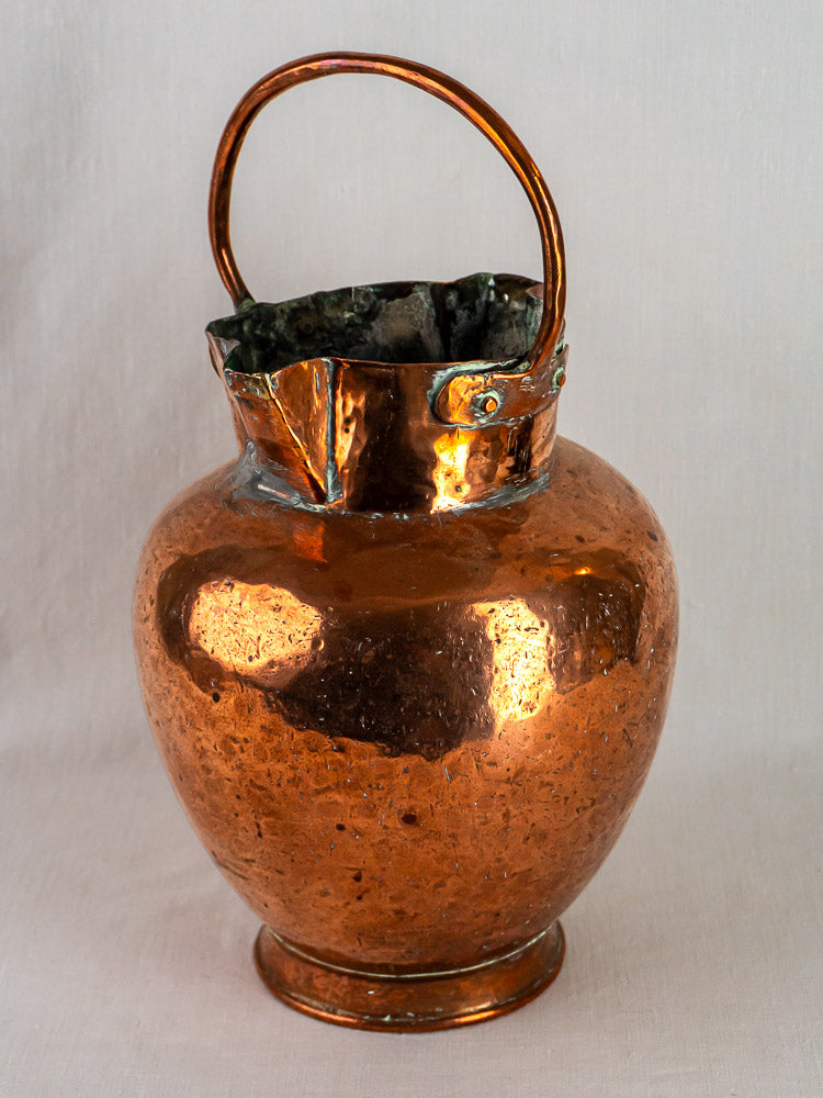 Antique French double-spout copper water jug with wide base, curved handle, and crimped rim.