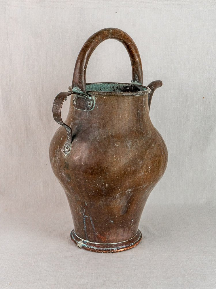 Antique French copper water jug with hand-worked details, weathered patina, neutral background.