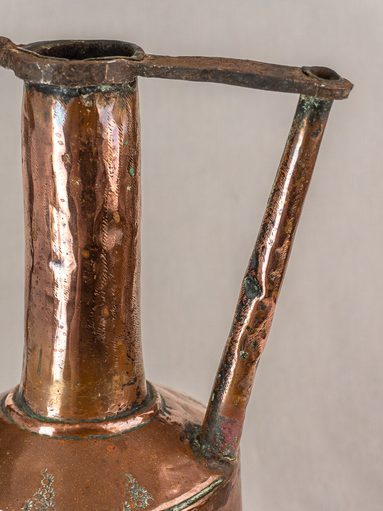 Antique French copper water jug with hand-hammered surface, iron handles, vertical spout, and rich aged patina.