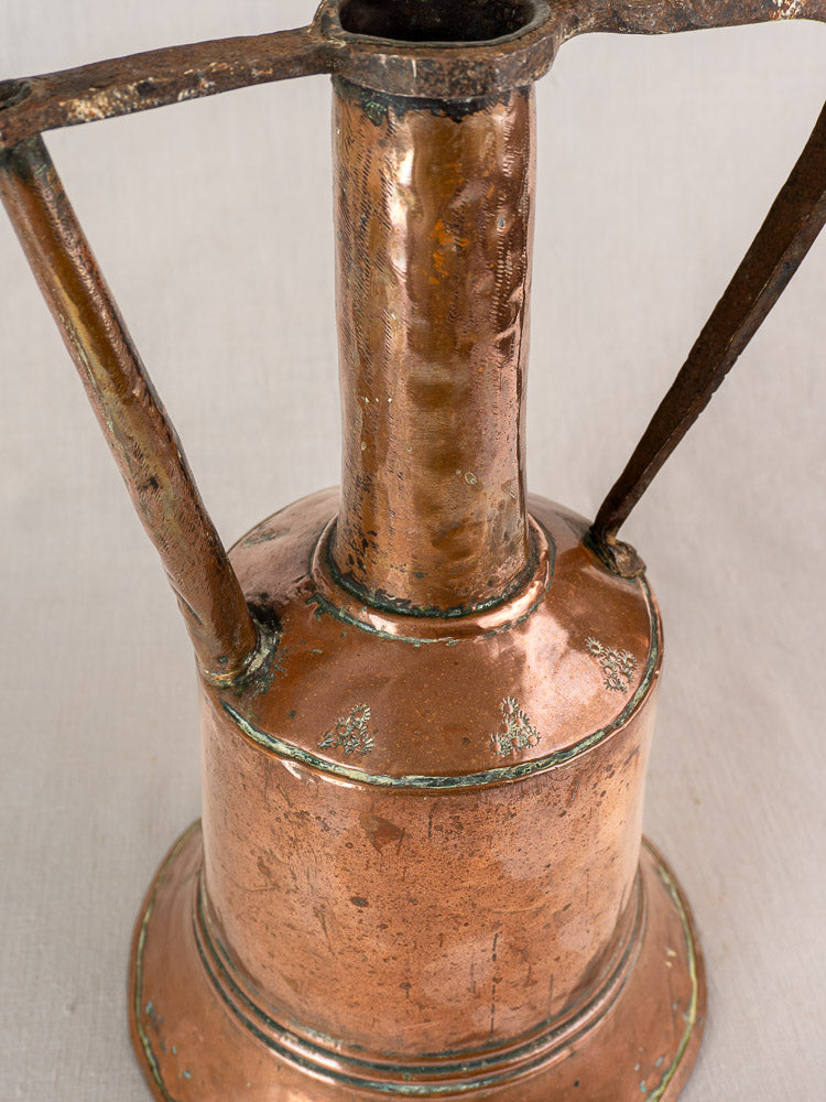 Antique French copper water jug with cylindrical body, wide base, tall neck, iron handles, and aged patina.