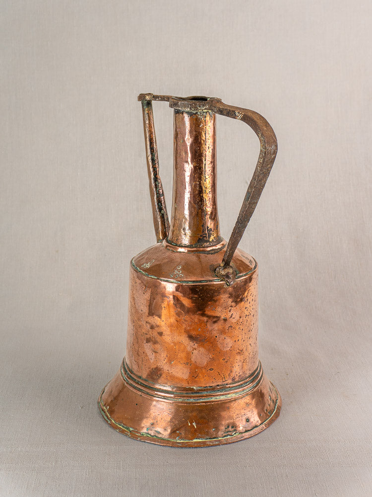 Hand-hammered antique French copper water jug with iron handles, tall neck, and flared base, worn patina.