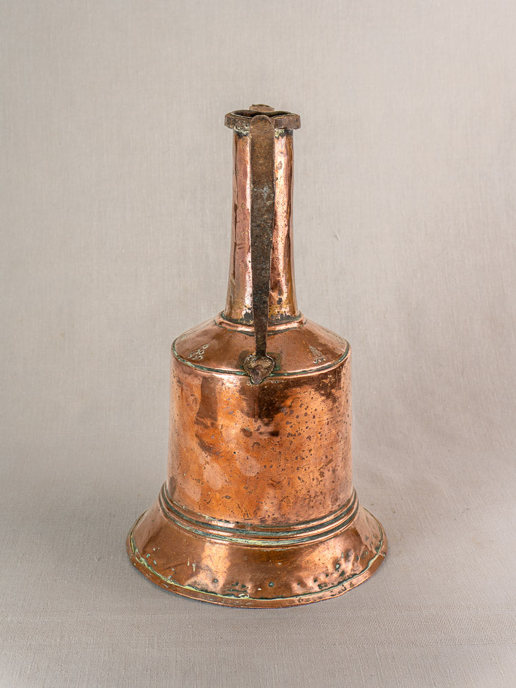 Antique French hand-hammered copper water jug with iron handles on a light gray background.