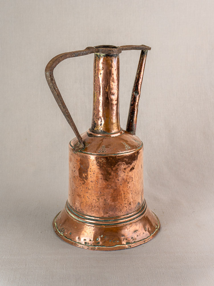 Antique French copper water jug with tall spout, wide base, curved iron handle, and aged patina on neutral background.
