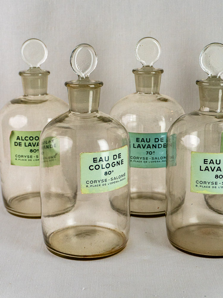 Set of five vintage French Coryse-Salomé glass perfume bottles with round stoppers and French labels.