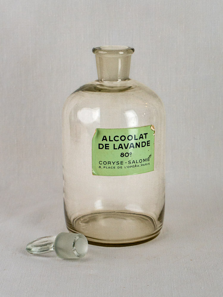 Set of five Coryse-Salomé Parfumerie clear glass bottles with matching stoppers on white surface.