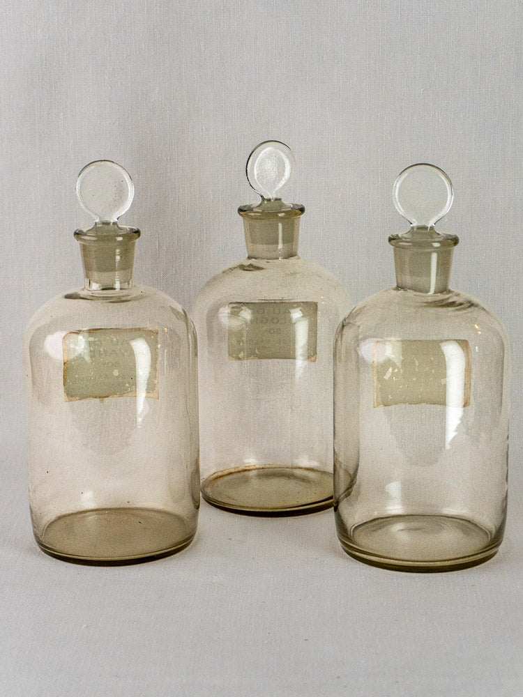 Five Coryse-Salomé French glass perfume bottles with round stoppers and vintage labels grouped together.