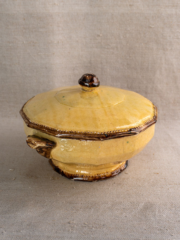 Mustard-glazed French Vallauris Beretta et Cie three-piece pottery tableware set with brown accents on beige fabric.