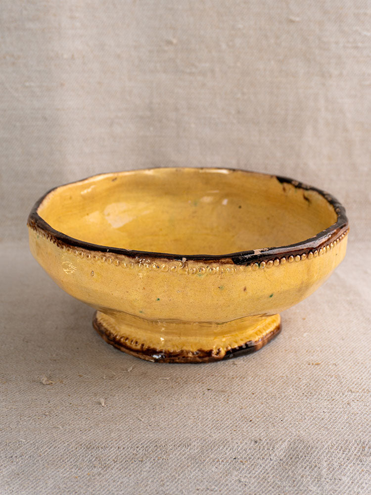 Mustard-glazed French pottery bowl by Vallauris Beretta et Cie with dark rim and artisan details, part of a three-piece set.