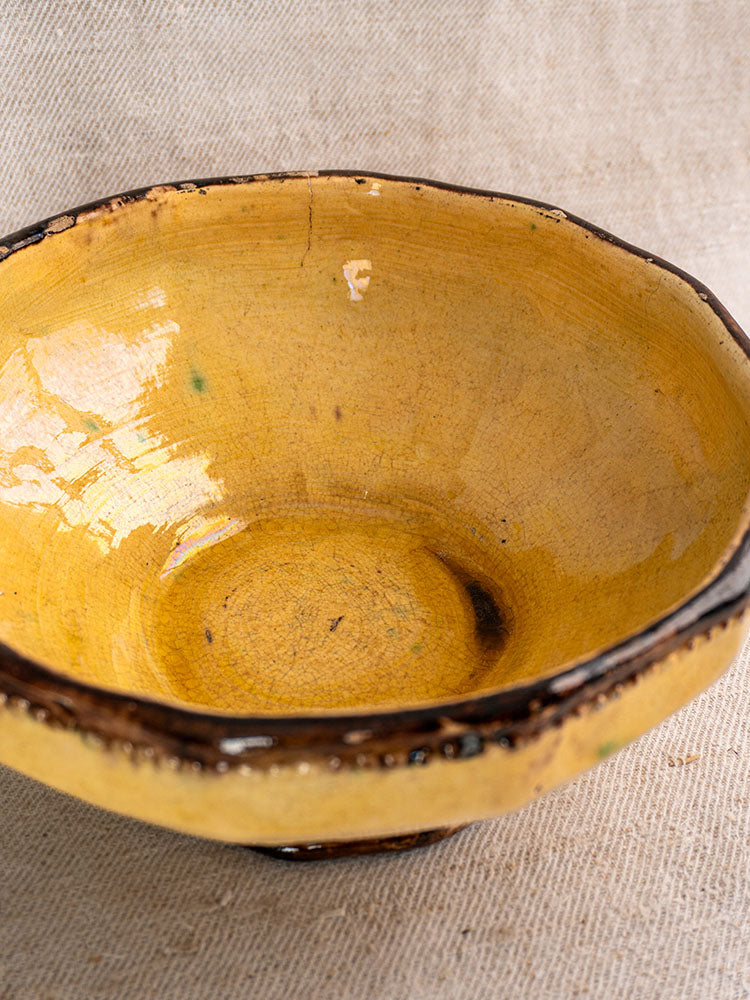 Vallauris Beretta et Cie mustard-glazed French pottery table service, three pieces, bowl with dark brown rim on beige fabric.