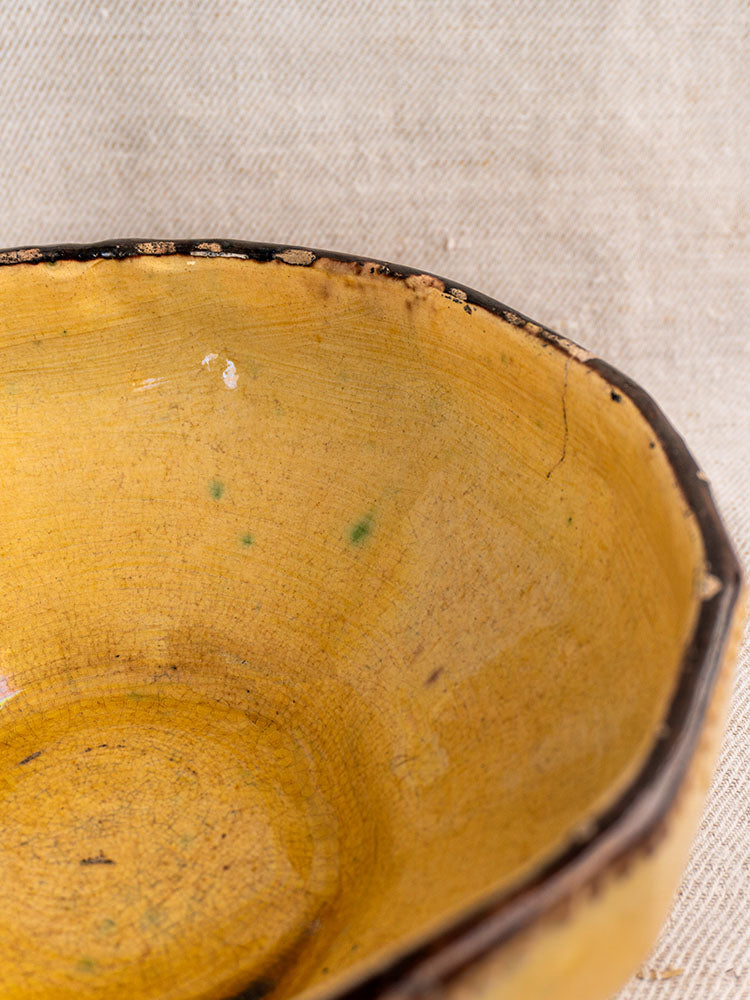 Vallauris Beretta et Cie French pottery table service, mustard-glazed three-piece set with rustic, worn edges on neutral fabric.