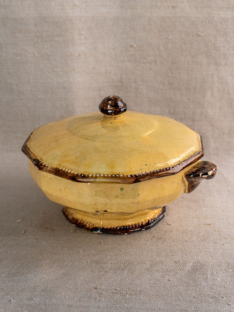 Antique Vallauris Beretta et Cie mustard-glazed octagonal tureen with lid, brown edges, on beige fabric.