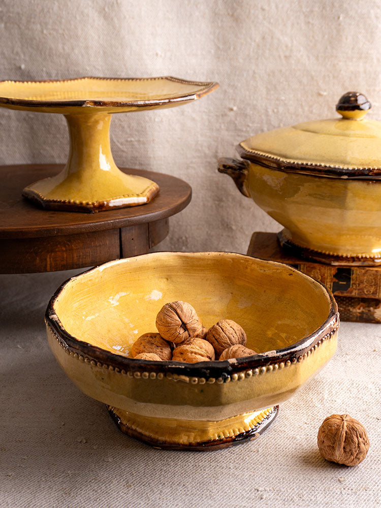 Vallauris Beretta et Cie mustard-glazed pottery set: bowl with walnuts, lidded pot, and platter on rustic beige cloth.