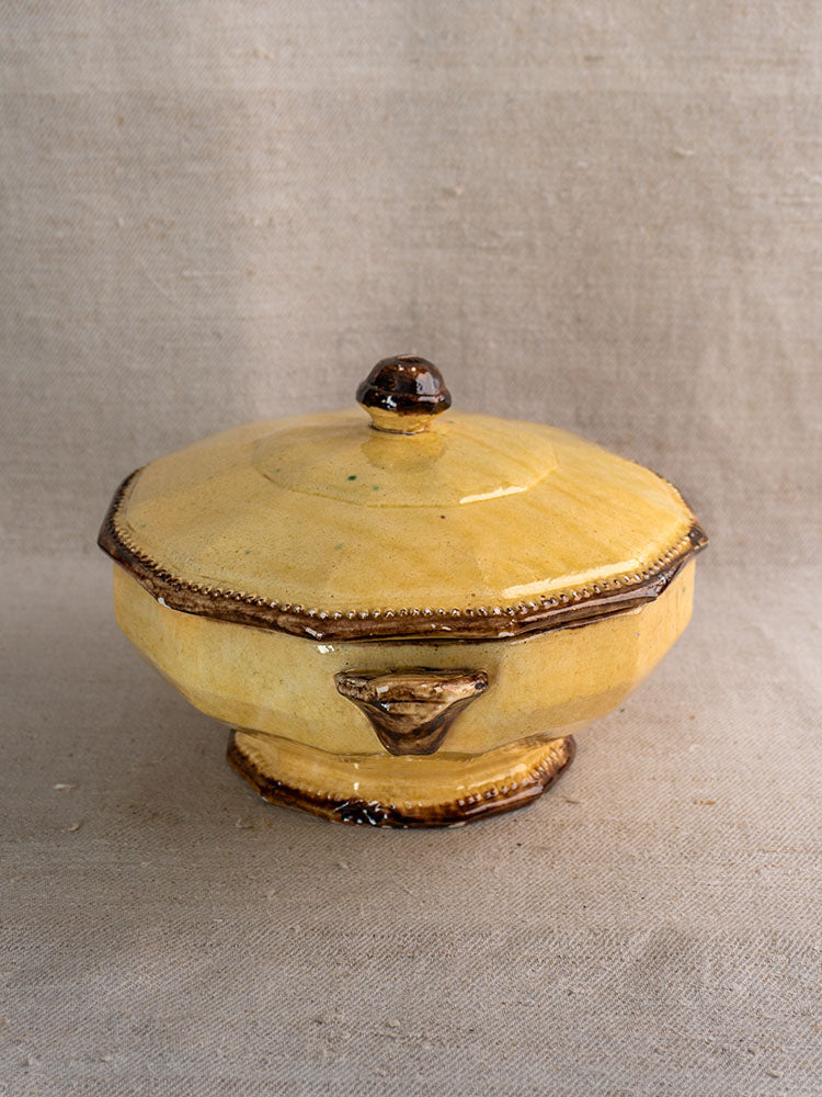 Small octagonal yellow ceramic dish with lid by Vallauris Beretta et Cie on neutral fabric.