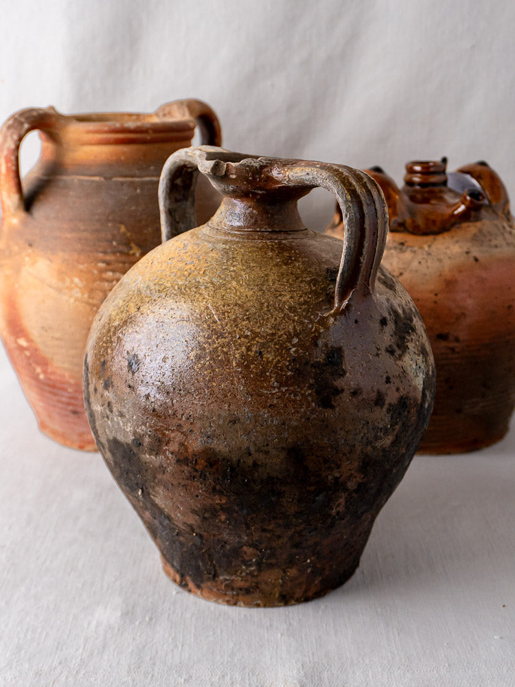 Set of three antique French terracotta Orjols with weathered textures and earth-toned hues.