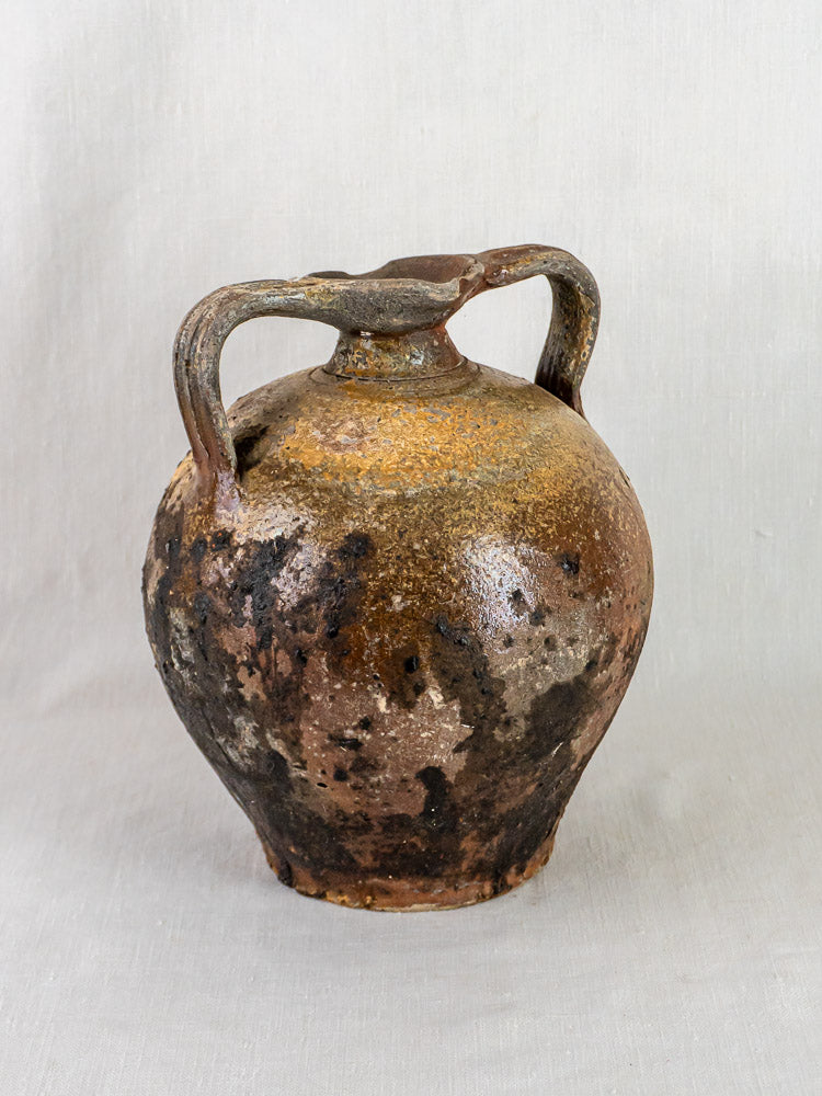Antique French Orjol, 18th-century two-handled terracotta jar with weathered brown surface on neutral background.