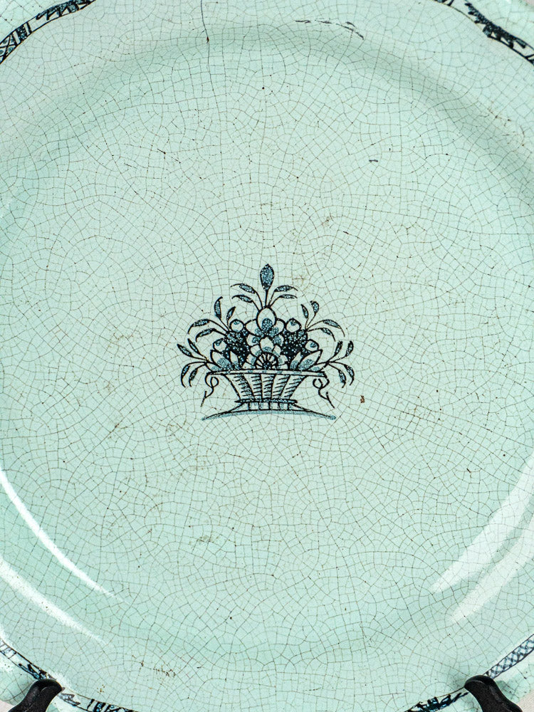 19th-century French faience Cul Noir charger with blue fruit basket motif and decorative border.