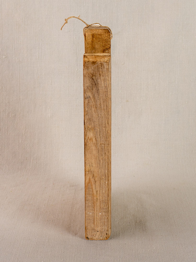 Antique French light oak cutting board, late 19th century, hand-carved, upright with string loop on neutral background.
