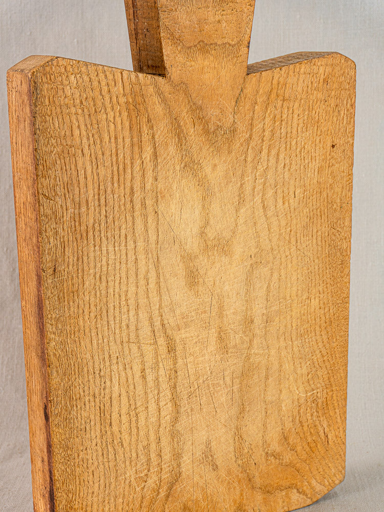 Antique French hand-carved wood cutting board with rich grain and farmhouse character on a neutral background.
