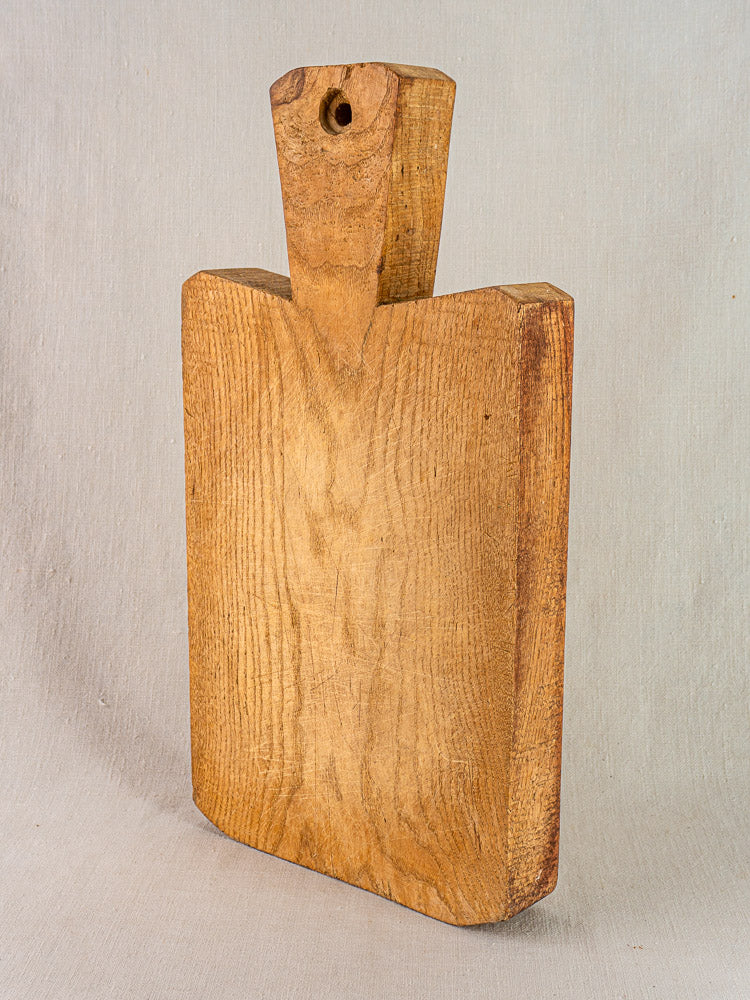 Antique French cutting board, thick hand-carved wood with handle and rustic grain, farmhouse kitchen decor.