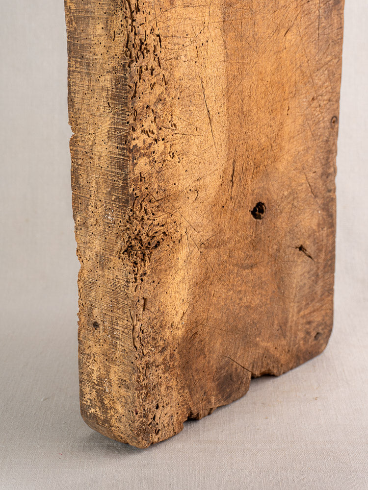 Antique French cutting board with thick, weathered wood, textured edges, and visible grain, vintage farmhouse decor.
