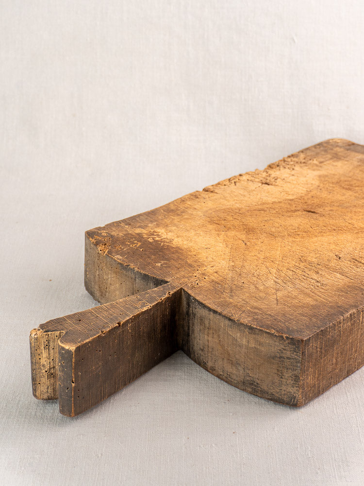 Antique French cutting board, rectangular with short thick handle and visible wood grain, charmingly worn vintage decor.