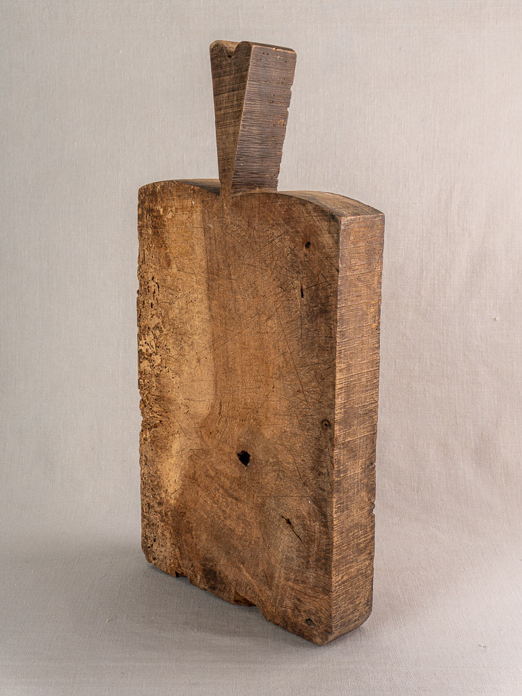 Antique French cutting board, circa 1880s, with thick rectangular form and tall wedge handle, displayed on a neutral background.