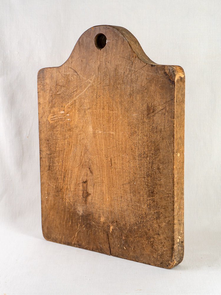 Antique French beech chopping board, circa 1900, with rounded top and worn, richly textured surface.