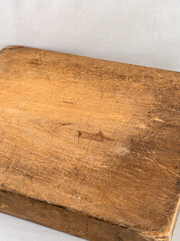 French antique beech chopping board c. 1900, with knife marks and scratches on pale background.