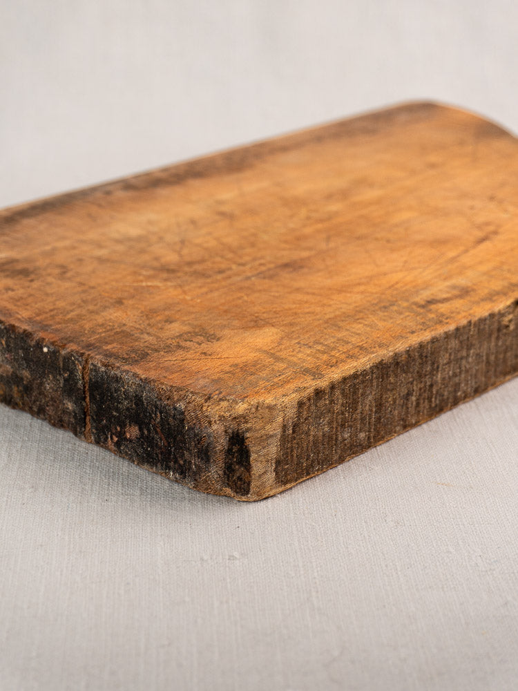 Antique French cutting board, single plank, late 19th century with aged patina on a light surface.