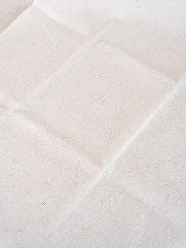 Antique French damask linen napkin, white, textured finish, center embroidered "AB" monogram, from a set of 12.