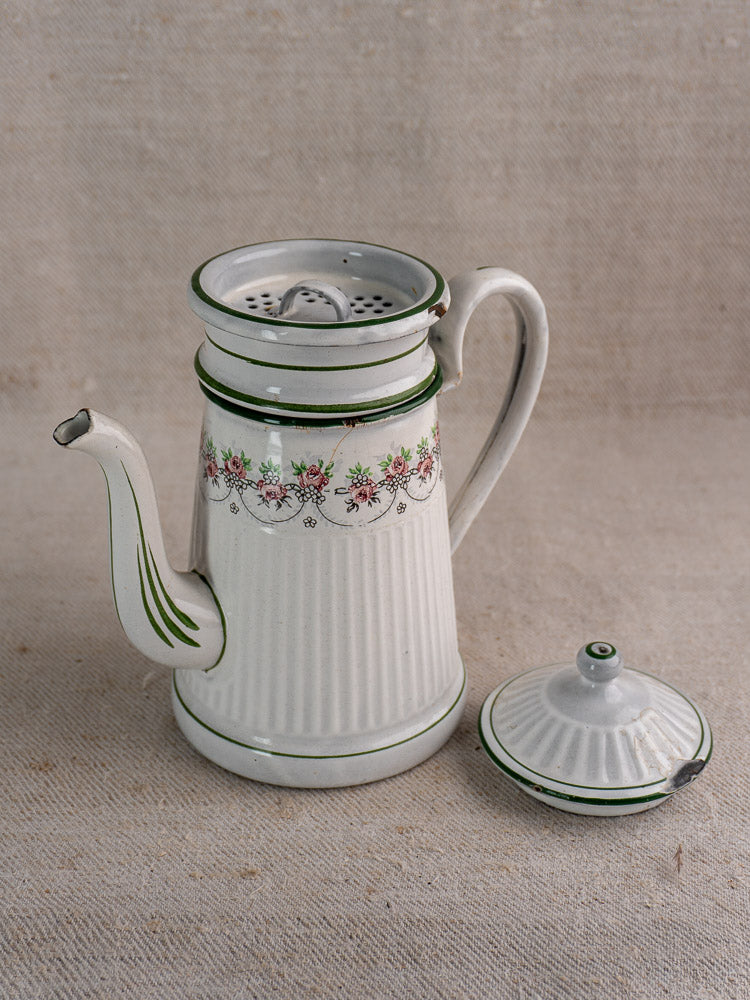 Antique French enamel coffee pot by B.B. Frères, green striped with floral design and strainer insert, lid beside on fabric.