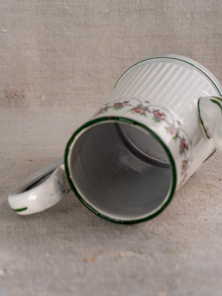 Antique French enamel coffee pot by B.B. Frères, circa 1910-20s, white with green rim and pink floral motif on beige fabric.