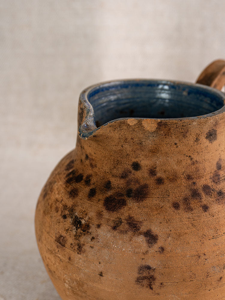 Antique French terracotta pitcher, mid-19th century, with rustic texture and cobalt blue glazed interior.