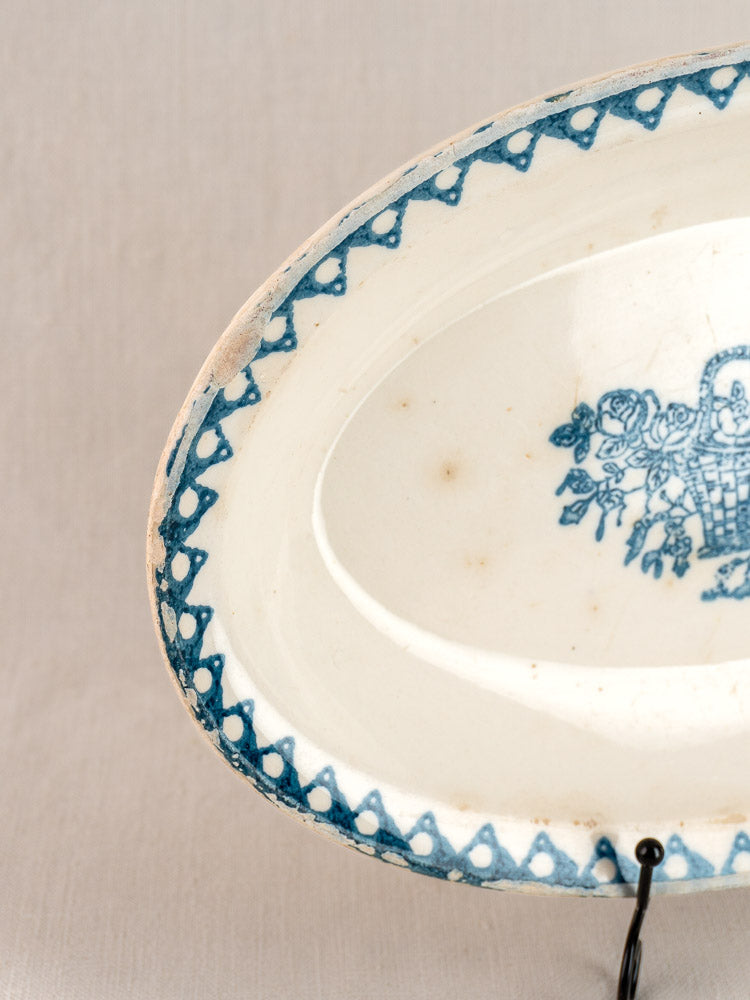 Antique French faience oval plate by Bertrand Opaque Surfine with blue zigzag border, floral basket, light wear, on stand.