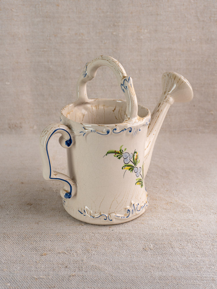Hand-painted French faience watering can with blue and green floral motifs, antique glaze patina.
