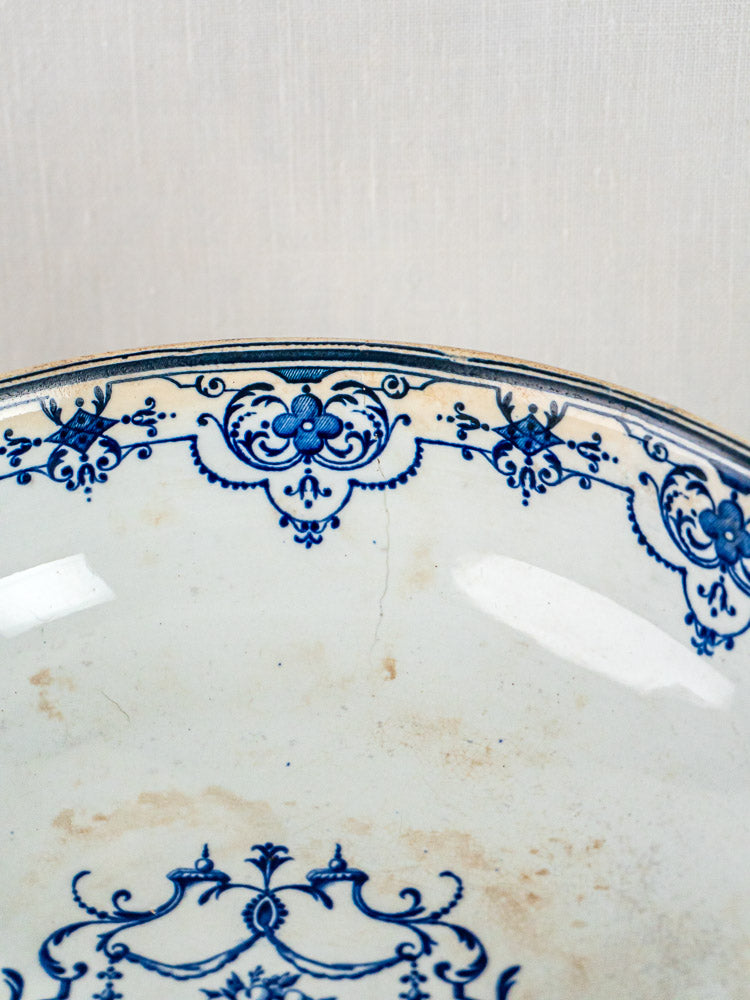 Antique French faience plate with blue floral rim, visible aged stains, Blue Moustiers style.