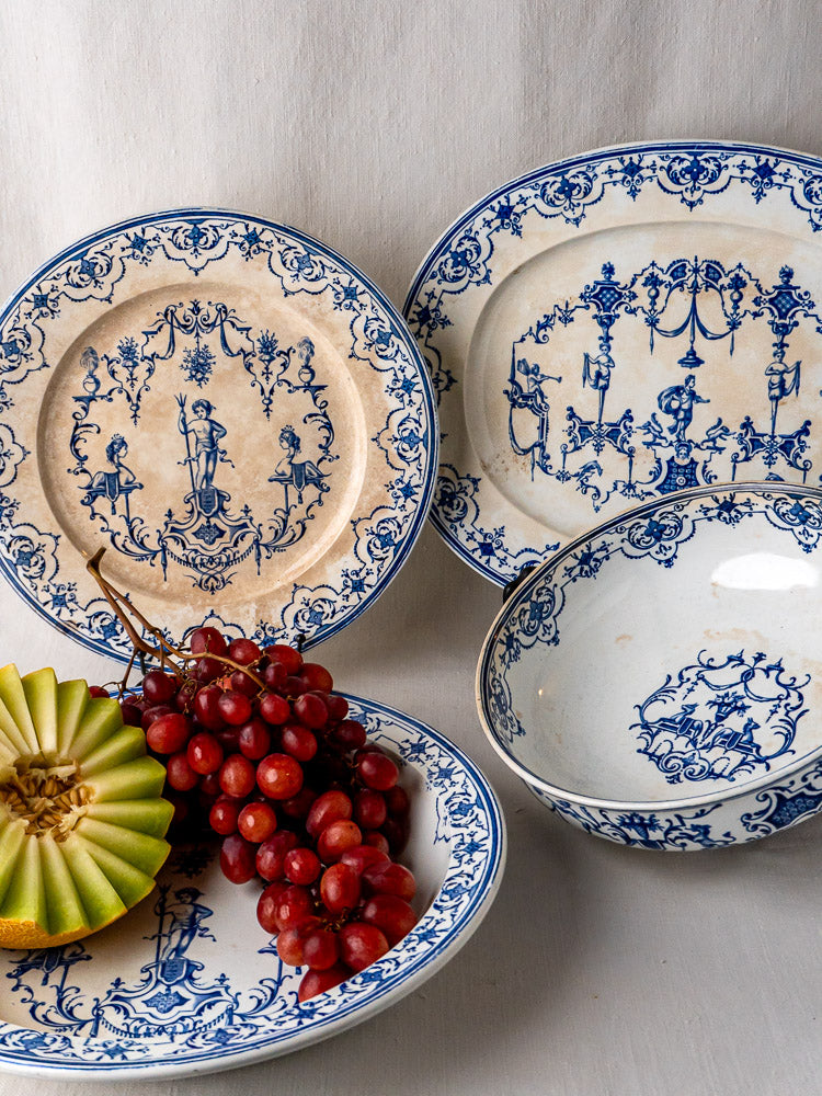 Set of four Jules Vieillard Bordeaux Moustiers French faience plates with floral designs, on neutral fabric.