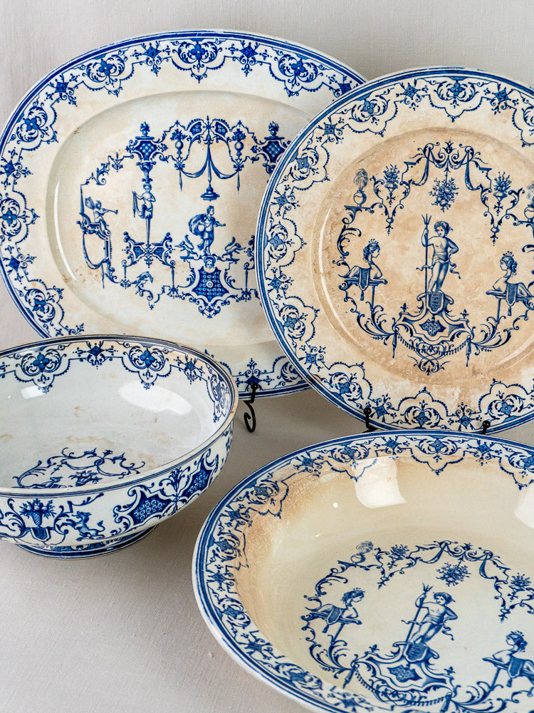 Set of four antique French ceramic dishes with blue faience Moustiers patterns on cream, aged patina.