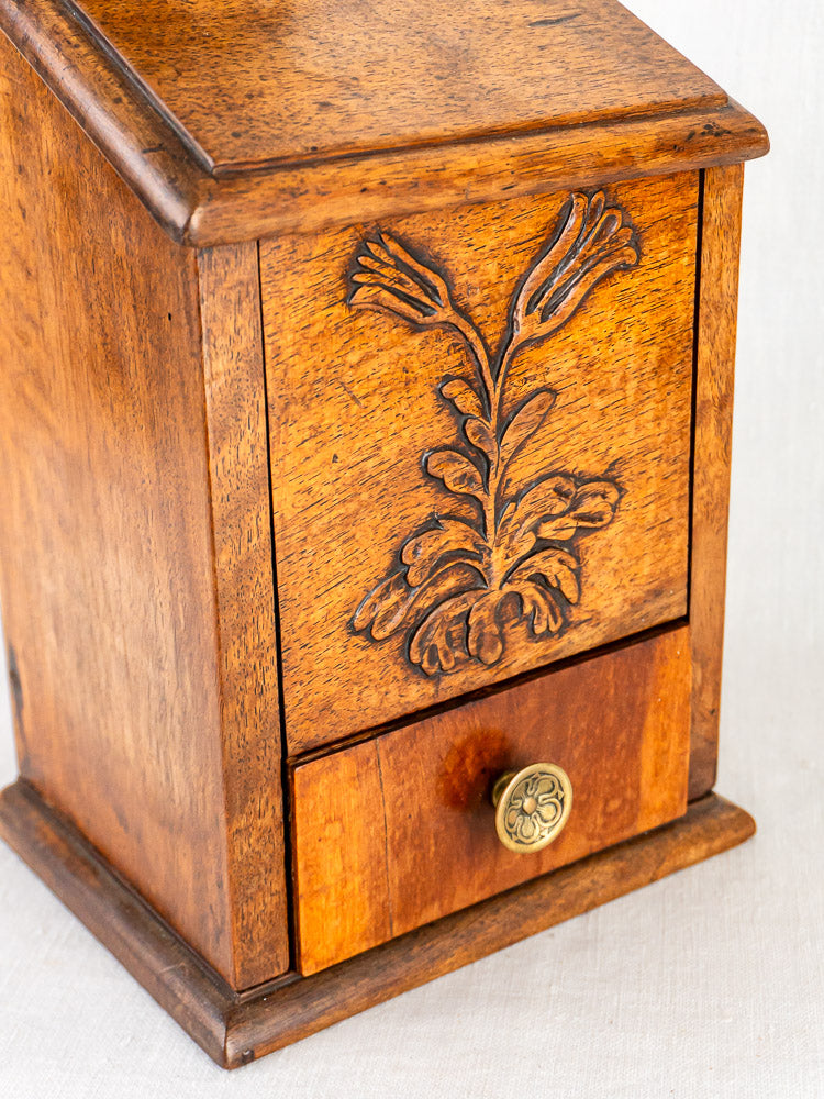 Antique French carved walnut flour and salt box with floral motif and ornate metal knob.