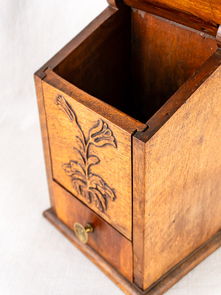 Antique French carved walnut flour and salt box with floral motif and brass-knob drawer, lid open.