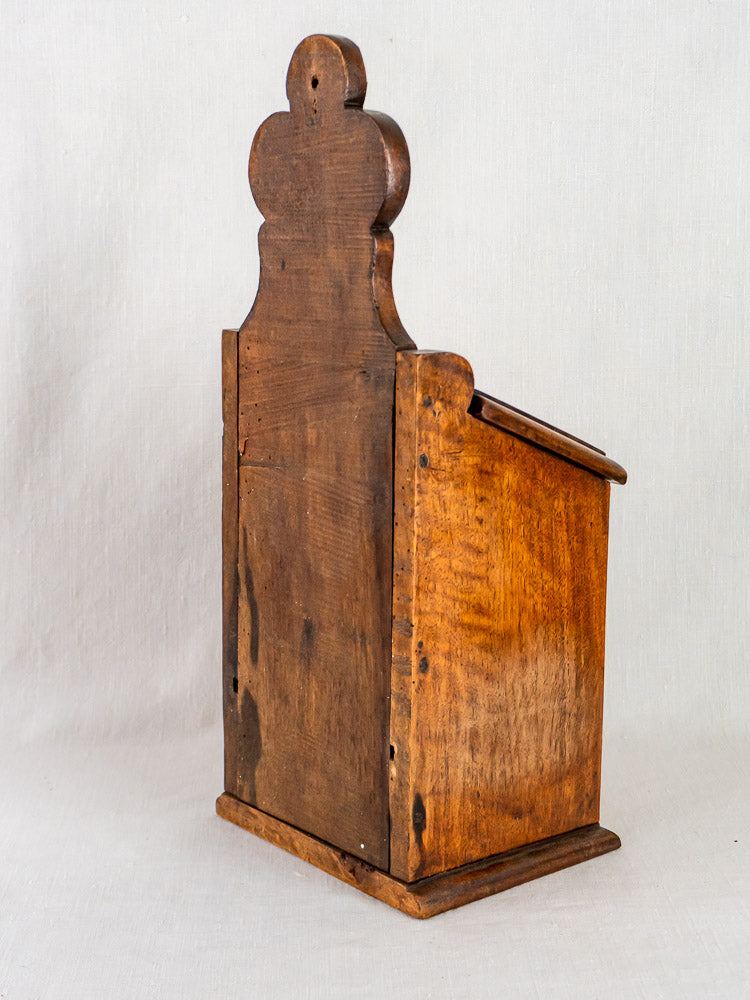 Antique French carved walnut flour and salt box with tall decorative back, rustic finish, plain background.